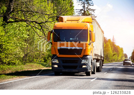 Modern orange truck tractor carries international cargo in a private company, business, industry 126233828