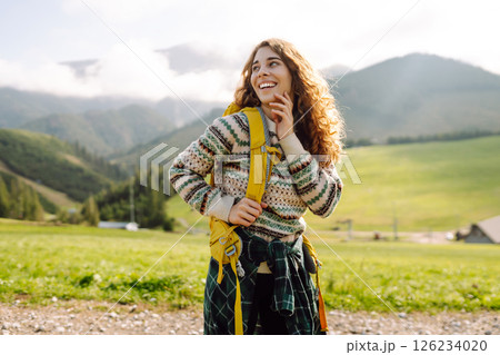 Female tourist with yellow backpack on top of mountain enjoying view of valley. Hiking concept. Female tourist with yellow backpack on top of mountain enjoying view of valley. Hiking concept. 126234020
