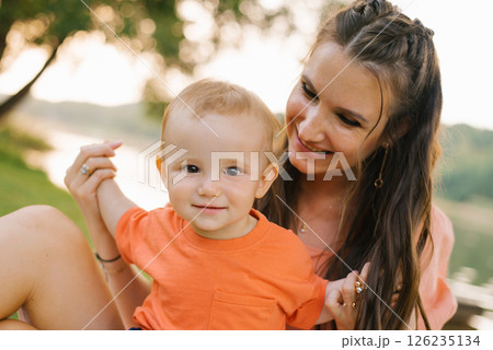 Baby Smiling With Mother Outdoors Baby Smiling With Mother Outdoors 126235134