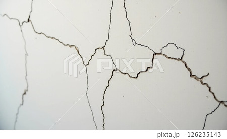 Intricate cracks traverse a weathered wall, showcasing the passage of time in an urban environment. Light filters through, emphasizing the delicate lines and textures Generative AI 126235143