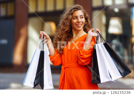 Young woman with shopping bags near mall. Purchases, shopping, lifestyle, sale concept. Young woman with shopping bags near mall. Purchases, shopping, lifestyle, sale concept. 126235236
