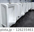 Row of White Urinals in a Public Restroom. 126235461