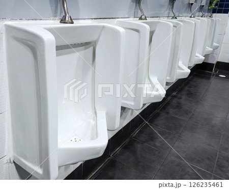 Row of White Urinals in a Public Restroom. 126235461
