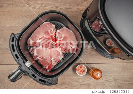 Raw pork chop meat with spices ready to cook in air fryer. top view 126235533