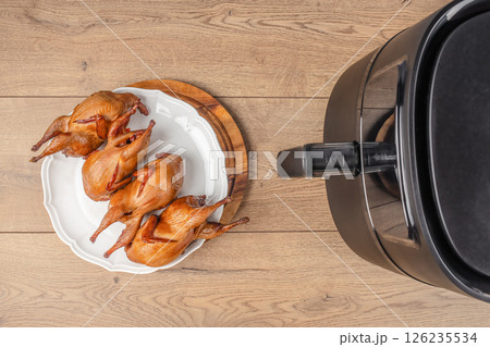 Baked quail air fryer oven on a wooden background. top view. copy space Baked quail air fryer oven on a wooden background. top view. copy space 126235534