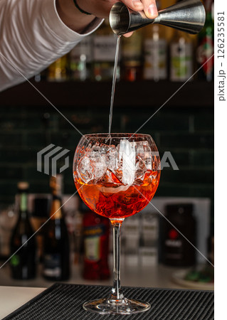 Aperol spritz cocktail in a glass with ice and orange, minimal trendy shot. Alcohol aperol spritz aperetivo Aperol spritz cocktail in a glass with ice and orange, minimal trendy shot. Alcohol aperol spritz aperetivo 126235581
