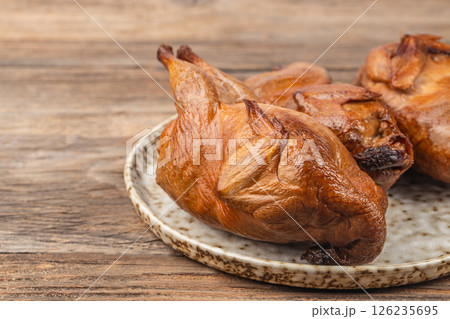 Tasty Smoked grilled quail meat with thyme on a wooden board 126235695