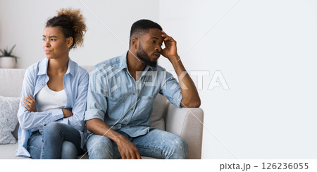 Misunderstanding In Relationship. Frustrated Black Man And Woman Avoiding Eye Contact Sitting On Couch At Home. 126236055