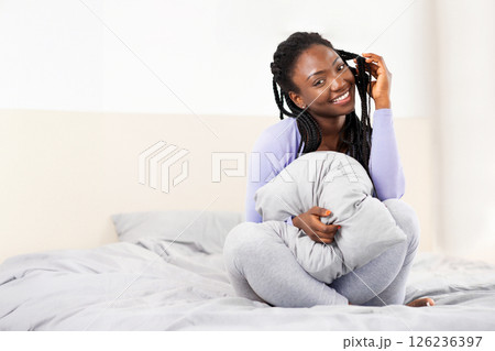 Smiling Black Lady Holding Blanket Playing With Braided Hair Sitting And Posing In Bed At Home In Morning. Selective Focus 126236397