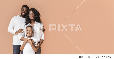 Happy Family Of Three Hugging Posing Over Yellow Background In Studio 126236475