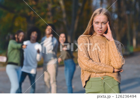 Upset blonde girl over laughing and pointing multiracial group of teenagers 126236494