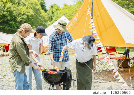 キャンプでバーベキューを楽しむ男女 126236666