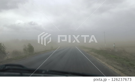 Driving in the rain. fog over the road, sandstorm on the way, strong wind, extreme weather conditions on the highway. Driving in the rain. fog over the road, sandstorm on the way, strong wind, extreme weather conditions on the highway. 126237673