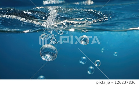 Underwater bubbles rise through blue water creating rippling effects and a sense of tranquility in a serene aquatic environment 126237836