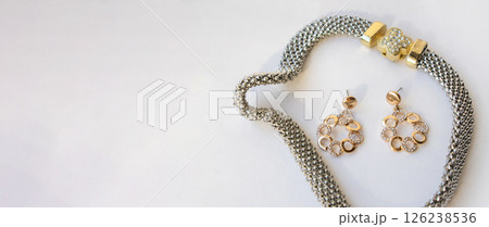 Banner with romantic jewelry set of sterling silver choker necklace and round chain earrings on white background, copy space 126238536