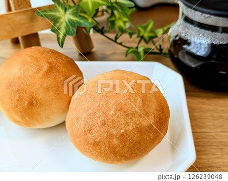 お皿にのった手捏ねの丸いパンとコーヒー 126239048