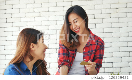 Two friends shopping using credit card online shopping on website laptop e-commerce website with smiling face, happiness. Happy asian women using laptop shopping online buy, payment newnormal concept Two friends shopping using credit card online shopping on website laptop e-commerce website with smiling face, happiness. Happy asian women using laptop shopping online buy, payment newnormal concept 126239421