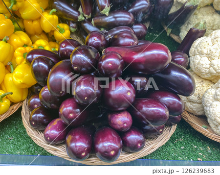 Fresh eggplants lie in a pile at the store on the counter for sale Fresh eggplants lie in a pile at the store on the counter for sale 126239683