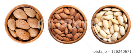 Almonds in shell, shelled and skinless, in wooden bowls. On the left side unshelled almonds, in the center with their shell removed, but still with brown seed coats, and blanched on the right side. Almonds in shell, shelled and skinless, in wooden bowls. On the left side unshelled almonds, in the center with their shell removed, but still with brown seed coats, and blanched on the right side. 126240671