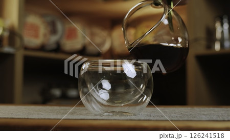 A person pours coffee, tea, and wine, showcasing beverage art. Media 126241518