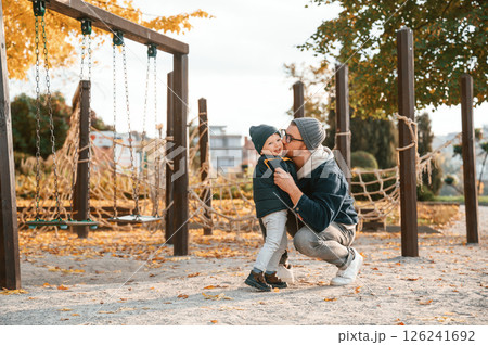 On the playground. Father and young son is together outdoors at daytime 126241692
