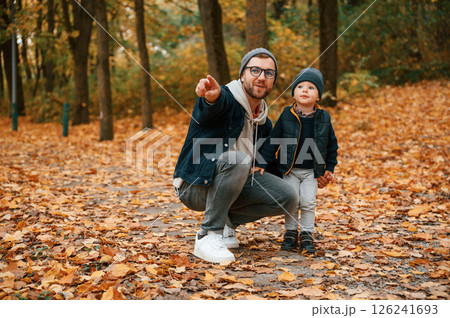 In the autumn forest. Father and young son is together outdoors at daytime 126241693