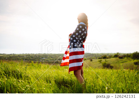 Young woman with american USA flag on blooming meadow. Independence Day, 4th July. 126242131
