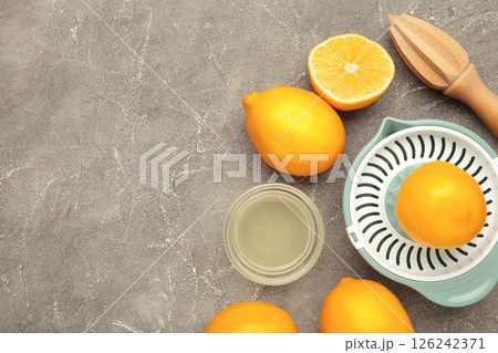 Wooden hand juicer and cut lemons. Squeezing lemons for lemonade or food preparation. Wooden hand juicer and cut lemons. Squeezing lemons for lemonade or food preparation. 126242371