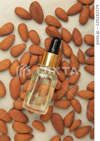 Fresh almond oil with almond nuts on light background. Vertical photo Fresh almond oil with almond nuts on light background. Vertical photo 126242374