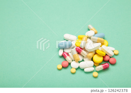 Various colored pills on mint background. Space for text Various colored pills on mint background. Space for text 126242378