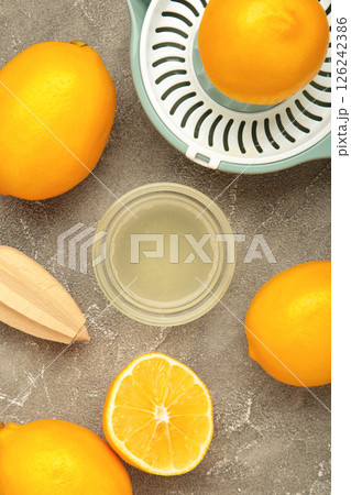 Wooden hand juicer and cut lemons. Squeezing lemons for lemonade or food preparation. Wooden hand juicer and cut lemons. Squeezing lemons for lemonade or food preparation. 126242386