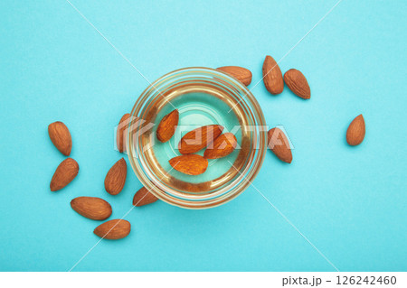 Fresh almond oil with almond nuts on blue background. 126242460