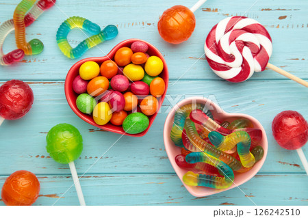 Different types of candies on blue wooden background, copy space. Colorful birthday party background. Different types of candies on blue wooden background, copy space. Colorful birthday party background. 126242510
