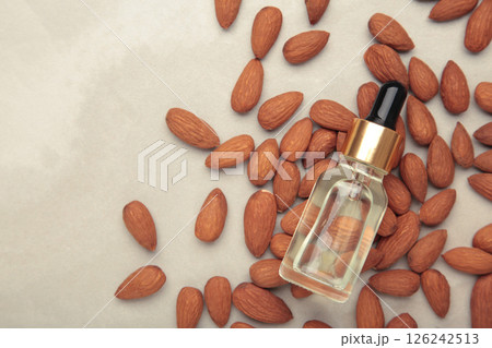 Almond oil with almond nuts on grey background. 126242513
