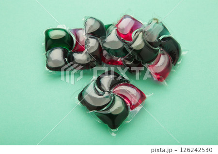Gel capsules with laundry detergent on mint background Gel capsules with laundry detergent on mint background 126242530