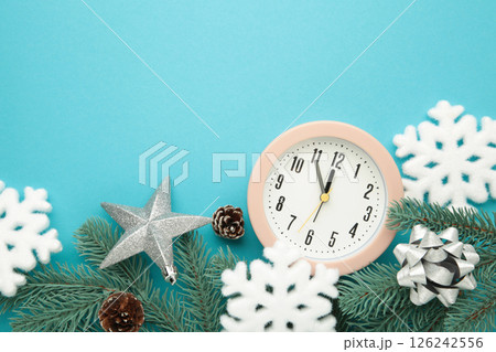 Alarm clock with white snowflakes and fir tree on blue background. Alarm clock with white snowflakes and fir tree on blue background. 126242556