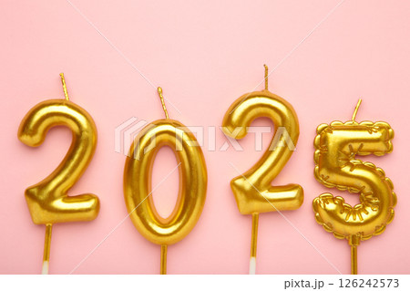 Holiday background Happy New Year 2025. Numbers of year 2025 made by gold candles on pink background. Holiday background Happy New Year 2025. Numbers of year 2025 made by gold candles on pink background. 126242573