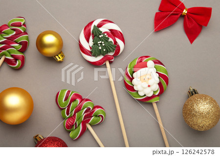 Christmas Candy with christmas ball on grey background. Sweet lollipop 126242578