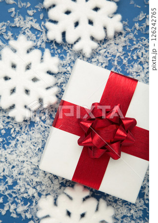 Merry Christmas and Happy Holidays. White Christmas gifts with white snowflakes on blue background. Vertical photo Merry Christmas and Happy Holidays. White Christmas gifts with white snowflakes on blue background. Vertical photo 126242765