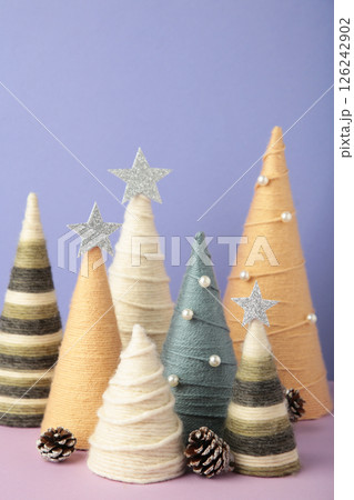 Handmade Christmas trees on purple background. Yarn wrapped cone trees. DIY concept. Vertical photo Handmade Christmas trees on purple background. Yarn wrapped cone trees. DIY concept. Vertical photo 126242902