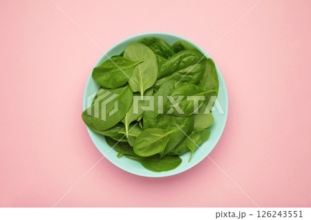 Spinach leaves with water drops in mint bowl on pink background. Raw organic spinach greens. Vertical photo Spinach leaves with water drops in mint bowl on pink background. Raw organic spinach greens. Vertical photo 126243551