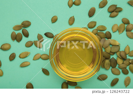 Pumpkin seed oil and seeds on mint background. Pumpkin seed oil and seeds on mint background. 126243722
