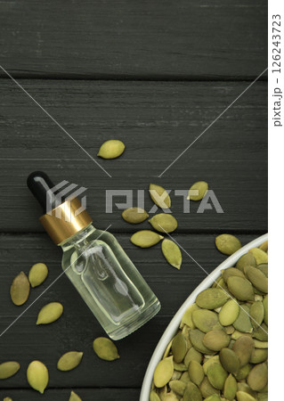 Pumpkin seed oil on black wooden background. Top view Pumpkin seed oil on black wooden background. Top view 126243723