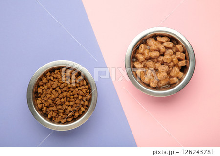 Wet and dry food for dogs and cats in silver bowl on pink background. 126243781