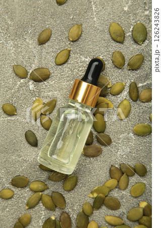 Pumpkin seed oil on grey concrete background. Top view 126243826