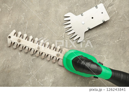 Hedge Trimmer New cordless hedge trimmer on grey concrete background Hedge Trimmer New cordless hedge trimmer on grey concrete background 126243841