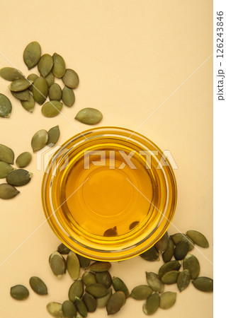 Pumpkin seed oil and seeds on beige background. Vertical photo Pumpkin seed oil and seeds on beige background. Vertical photo 126243846