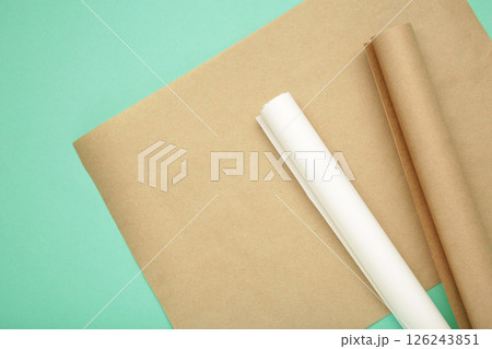 Rolls of white and brown baking paper on mint background 126243851