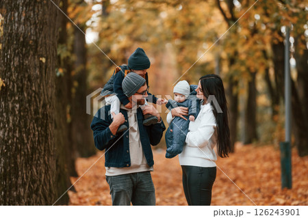 Father with his son on hands walking with mother that is with toddler 126243901