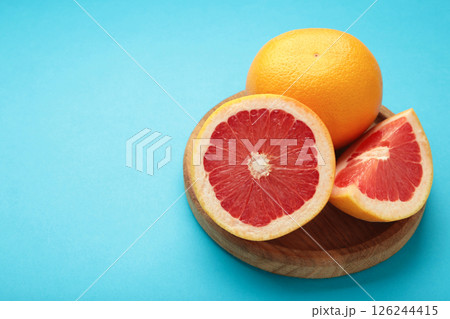 Whole grapefruit with slice on blue background. Whole grapefruit with slice on blue background. 126244415